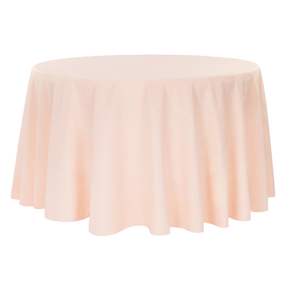 Round table covered with a blush/rose gold tablecloth on a white background