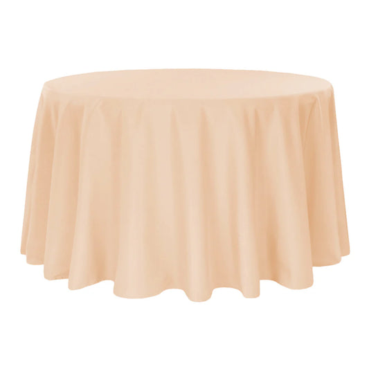 Round table covered with a champagne-colored tablecloth on a white background