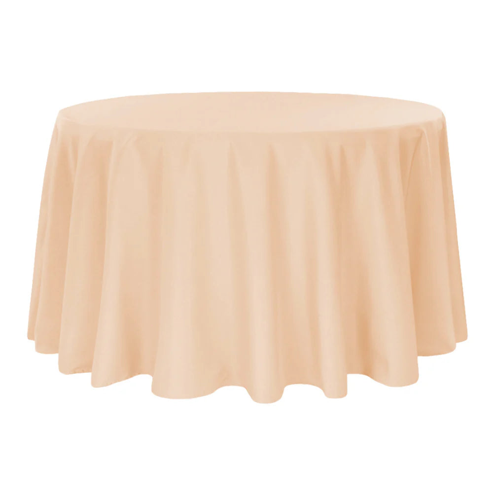 Round table covered with a champagne-colored tablecloth on a white background